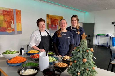 Victoria Skydt (i midten) med sin klassekammerat Jessica Vester gør klar til frokosten på Sdr. Feldings Efterskole med at anrette salatskålene. På skolen skiftes eleverne til at være i køkkenet en uge ad gangen. Assisterende køkkenleder Malene Ebbesen ses til venstre.