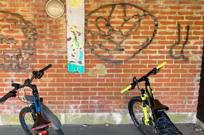 Det er ikke just den store kunst, der er blevet spraymalet ud på væggene her ved cykelskuret på Timring Læringscenter.