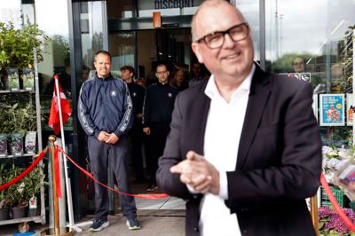 Salgsdirektør Mads Nysted fra Rema 1000 stod for den officielle åbning af butikken på Dæmningen. I baggrunden ses købmand Uffe Asbjørn Jensen og flere blandt personalet.