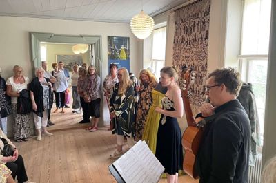 Der var stor interesse og dermed trængsel, da guitaristen Allan Sjølin og operasangerinden Nana Bugge Rasmussen ledte publikum musikalsk gennem den nye udstilling på Herningsholm. De havde sammensat et repertoire med forbindelse til de udstillede kostumer, og her var de standset ved forestillingen ”Ravnen”.Foto: Museum Midtjylland
