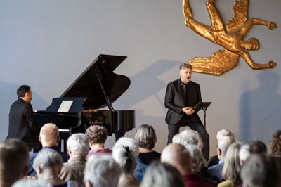 Peter Lodahl, en af initiativtagerne til Herning Opera Festival, var sammen med pianisten Søren Rastogi tilbage i byen for at åbne årets festival. Det skete i det tidligere gymnasiums velklingende aula, flankeret af Jørgen Gudmundsen-Holmgrens smukke »Ikaros«, der netop i år fylder 70 år på den bagvæg. Foto: Herning Opera Festival