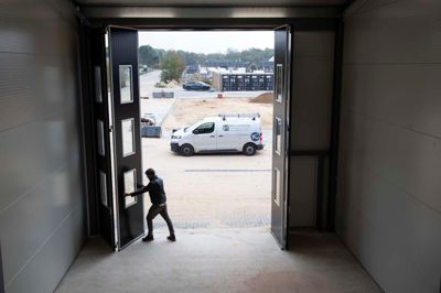 Kristian Helms viser de store porte frem. De er lavet i Sverige, og den sorte bygning har et tydeligt nordisk præg. Der er også ved at blive sat lysere træpaneler op udenfor - træpaneler, som også kommer til at være at se udenfor hos Sørens Camping, så de to bygninger står godt sammen.