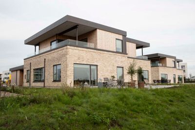 De nye dobbelthuse er skudt op helt ned til vandet ved Fuglsang Sø. De lyse mursten adskiller sig lidt fra den oprindelige plan om en facade bestående af hvid indfarvet beton.