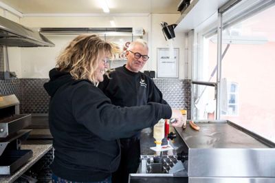 Diana og Allan Hviid Pedersen i deres pølsevogn, Moster Di’s, hvor de sammen serverer hotdogs og godt humør. Parret bor på en landejendom mellem Sdr. Felding og Troldhede.