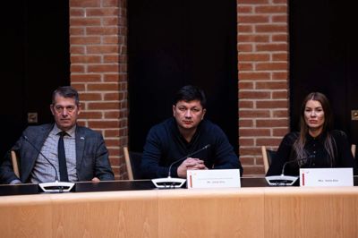 I midten sidder Vitalii Kim flankeret af borgmester i Ikast-Brande Kommune, Ib Lauritsen (V), og sin kone, Yulia Kim, som han fortæller har været en stor støtte i krigens kaos.