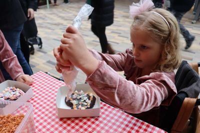 Stella Johannsen kan ikke gå- eller danse rundt om juletræet i år. Et brækket ben betyder, at hun må rulle rundt. Men hun kunne dog sagtens pynte honninghjerte i Strøgcentret søndag eftermiddag.