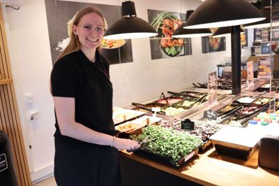 Natasja Mortensen har været ansat i Kylling og Co i Ikast ti år. Først som ungarbejder – og dag som daglig leder. Hun ses her foran den farverige og indbydende salatbar med blandt andet lokale radisespirer dyrket i Engesvang.