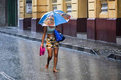 En kvinde går ned ad en ellers mennesketom gade i Santiago de Cuba, inden orkanen Melissa går i land.
