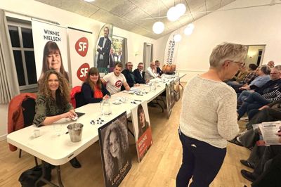 75 borgere fyldte den 5. november 2025 Fly Forsamlingshus, da der var vælgermøde med Else Th. Pedersen (th) som ordstyrer. Kandidaterne er fra venstre Lene Foged (LA), Winnie Nielsen (S), Rasmus Hansen (SF), Simon Højer (K), Martin Sanderhoff (M), Poul Erik Nygaard (DD) og Claus Clausen (V).