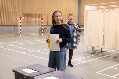 Traditionen tro hjalp Laura Jensen - til ære for fotografen - tirsdag igen med at putte sin mor Kristina Jensens stemmeseddel i stemmeurnen.
