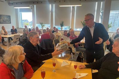 Formand for bestyrelsen, Martin Laursen, overrækker en gave til Aktivitetshusets medlem nummer 600, Niels Jørgen Nielsen.