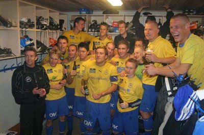 Kjelerup IFs førstehold - nærmest lutter lokale spillere - under en oprykningsfest med træner Jack Madsen, der var i klubben 2007-2008. Stig Duelund står lige ved siden af træneren.