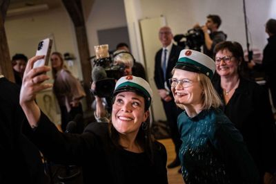 Astrid Kragh (S) og Sofie Lippert (SF) efter præsentationen af aftalen om en ny gymnasieuddannelse i februar. De to politikere har taget en grøn studenterhue på, som skal høre til epx. (Arkivfoto).
