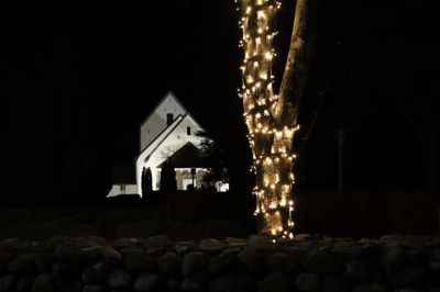 Smukt ser det ud, når man kan se den oplyste kirke og træerne med julelys.