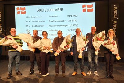 Jubilarer på stribe. Harro Christensen (lagermedhjælper, nyslået pensionist), Jan Jørgensen (halmester, 35-års jubilæum), Trine M. Vittrup (projektkoordinator, 25-års jubilæum), Søren Jensen (halmester, 25-års jubilæum), Knud Sørensen (Key Account Manager, 35-års jubilæum), Steen Lyngaa (halassistent, 40-års jubilæum), Helle Carstens (projektleder, 40-års jubilæum). Længst til venstre er det administrerende direktør i MCH, Georg Sørensen.