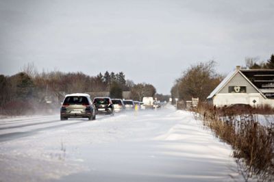 Der er varslet glatte veje og snefygning i store dele af landet lørdag. På Rute 16 mellem Ringkøbing og Tim fyger det med sne, og biler må køre forsigtigt på strækningen. (Arkivfoto).