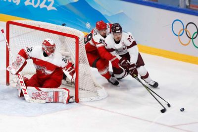 Oskars Cibulskis (t.h.) og Letland blev ved vinter-OL i 2022 slået 3-2 af Danmark i playoff-runden. Cibulskis var assisterende kaptajn for letterne. Her forsøger at at runde Mikkel Bødker, mens Sebastian Dahm ser til i målet.