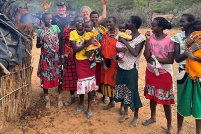 Søren Christian Sørensen og Glennie Grønne med kvinder i en masai-landsby. Kvinderne bor med deres børn i små, lerklinede hytter med åbne ildsteder, der brænder dag og nat. De bliver syge af al den røg, de indånder. Det problem kan Søren og Glennies løse med deres komfur- og skorstenskonstruktion.