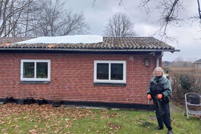 Rikke Bülow foran huset i Ørnhøj. Lillejuleaften blev en presenning lagt på taget, som Rikke Bülow fortæller har været utæt i de to år, hun har boet i huset.