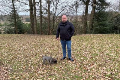 Klaus Gravesen og hans lille hund i haven, hvor de torsdag 22. januar mødte en ulv. Ulven stod i udkanten af haven kun få meter fra det sted, hvor Klaus Gravesen står nu.