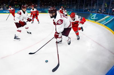 Morten Poulsen (t.h. med nummer 38) fik små fem minutter på isen i kampen mod Letland. Her forsøger han at få pucken fra Kaspars Daugavins.