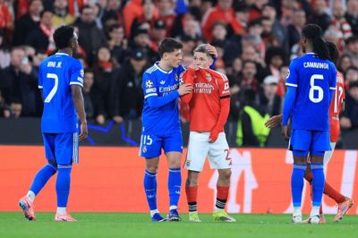 Benficas argentinske kantspiller Gianluca Prestianni dækker sin mund til, mens han kommer med en bemærkning i en diskussion med Real Madrids Vinícius Júnior. Real Madrids spillere anklager Prestianni for racistiske tilråb.