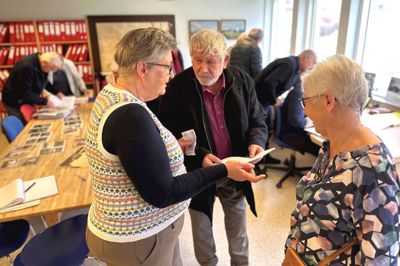 Æ Fjandboarkiv kunne lørdag den 24. februar 2024 fejre 50-års jubilæum. Det skete med en reception i lokalerne på det gamle rådhus på Iglsøvej, hvor det her er formand for Fjends Egnhistoriske Forening Turi Roslund (tv) og arkivleder Ruth Meller Sørensen (th), der gør Ib Brochholm, Fly, klogere på frivilligt arbejde i arkivet.