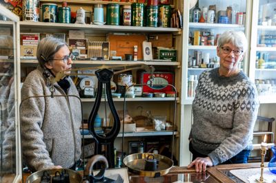 Liselotte Møller Pedersen (t.v.) er udstillingsansvarlig blandt de frivillige i Den Gamle Købmandsgård. Her ses hun med en af de øvrige frivillige, Johanne Kristensen.