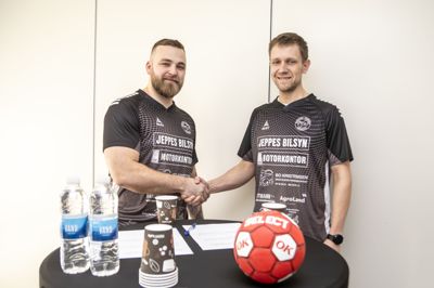 Træner Mads Harritz (tv) og formand for Mønsted/Sparkær Håndbold Mathias Bak Iversen giver hinanden håndslag på yderligere to års samarbejde.