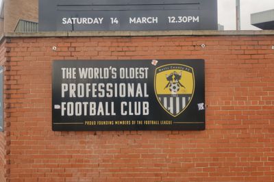 Hvis der er én ting, de er stolte over hos Notts County, så er det det faktum, at det er den ældste professionelle fodboldklub og medstifter af det engelske ligasystem. Det fremgår på skilte hele vejen rundt om stadion og på merchandise.
