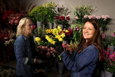 Da redaktionen var forbi i den forgangne uge, havde påskens gule og hvide farver endnu ikke indtaget hele butikken hos Kirstens Blomster på Borgergade. - Men det hele ender med at være i gule og hvide nuancer. Det er det, kunderne vil have og det, der er tradition for. Og påsken handler meget om traditoner, siger indehaver Pia Munksø (tv). Her med elev Lærke Kjærgaard Thygesen, der har været i kælderen efter friske forsyninger af gule påskeliljer.