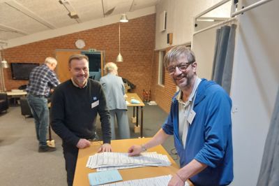 Anders Madsen i mørk trøje og de tilforordnede på valgstedet i Arnborg registrerede, at 140 vælgere - omkring hver ottende vælger - ikke havde fået deres valgkort i postkassen i Fasterholt og Arnborg. Til højre er det valgtilforordnede Niklas Pedersen.