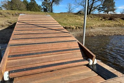 Den nye flydebro i Birkesø har fået skridsikkert bånd på den skrånende rampe.