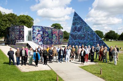 Frivillige og ansatte på Carl-Henning Pedersen & Else Alfelts Museum fotograferet foran museet, juni 2024. Gunhild Homilius står som nummer to fra venstre.