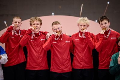 Martin Abildgaard (yderst til venstre) og Magnus Lindholmer (yderst til højre) var med til at sikre det danske guld. I midten står landstræner Oliver Bay, der også har fortid i Silkeborg Pigerne & Drengene.