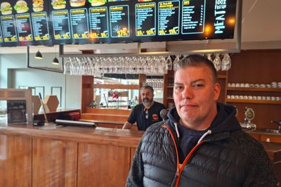 Casper Frausing havde bestilt tidligt, nemlig ved 16-tiden, og han fik sin mad til tiden. Han glæder sig over, at der er kommet et nyt burger-sted til byen. Tidligere brugte han Spisehuset ved Netto, men det er lukket. Pizzeriaer er der nok af i byen, mener han. I baggrunden ses medejer Jan Mustafa.