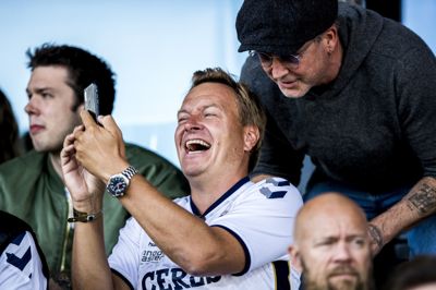 Rasmus Tantholdt (t.v.), der her tager en selfie med en anden AGF-kendis, sangeren Thomas Helmig, drømmer som mange aarhusianere om guld til hjerteklubben. Afgørende bliver de direkte dueller mod FCM, vurderer TV 2-korrespondenten.