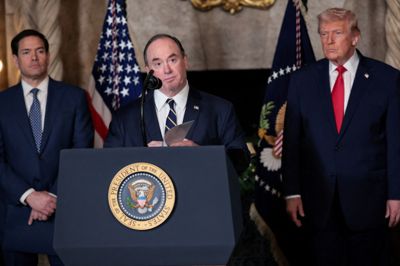 Flådeminister John Phelan ses i december sidste år udtale sig i Florida med Donald Trump i baggrunden. Phelan fratræder ifølge Pentagon øjeblikkeligt sin post.