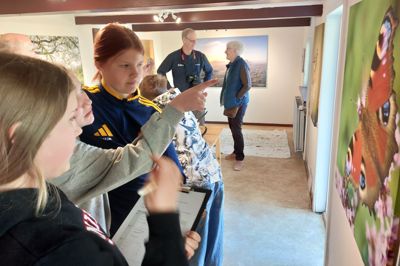 Nynne Andersen, i midten Victoria Kidde og til højre Hyben Paakjær ved et af naturbillederne, som Kibæk Fotoklub udstiller i Det Gule Hus i Nybro.