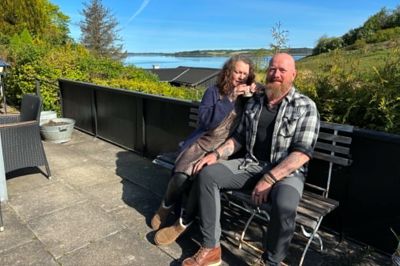 Ulla og Peter Holst Christensen ved sommerhuset med udsigt over Hjarbæk Fjord. De er faldet totalt for området.