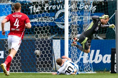 Målmand Nicolai Larsen får en flyvetur, mens OBs Anssi Suhonen kommer med en glidende tackling. Larsen ser dog ikke ud til at få brug for flyveture til sin kommende klub.