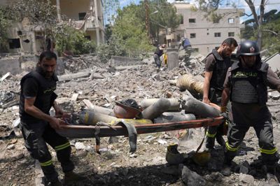 Redningsmandskab bruger en båre til at bære iltflasker og andet udstyr ud fra murbrokkerne af et af civilforsvarets centre i den sydlige by Nabatieh. Centret blev ødelagt i et israelsk luftangreb søndag. Rundt om i Libanon er mindst 11 mennesker dræbt i nye israelske angreb søndag, meddeler libanesiske myndigheder.