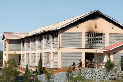 Sikkerhedsvagter står uden for sovesalen på en pigeskole i Kenya, hvor en brand brød ud natten til torsdag.