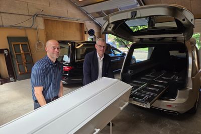 Thorkild Vad (t.h.) er her sammen med den ene af tre ejere i Ødegaard & Søgaard Begravelser Bjarne Søgaard ved at håndtere en tom kiste i de nye lokaler på Brogårdsvej. Her er plads til to af firmaets rustvogne