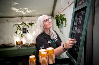 Gitte Nedergaard og hendes hold af frivillige er med til at sørge for god stemning omkring artisterne, når er backstage og gør klar til at gå på scenen. »Her smiler vi altid«, har hun skrevet på tavlen i musikerne spisetelt.