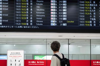 Billede fra mandag viser mand, der betragter skærm med flyafgange i Tokyo, hvor der kan ses aflysning som følge af stormen Jangmi.
