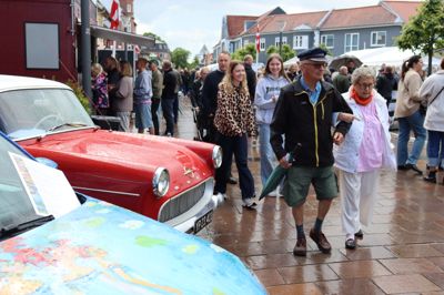 Det var en god idé at have paraply med ved årets veteranbiltræf. Den røde Opel tilhører Bjarne Pedersen, som sad i bilen og dyttede ad folk, han kendte.