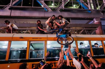 New York Knicks-fans løfter en cykel op på en bus i fejringen af basketballholdets NBA-titel.