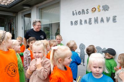 Brigitte Laugesen Toft markerer her, at Lions Børnehave nu har slettet Club som mellemnavn. Det var børnehavens mange børn med til at markere.