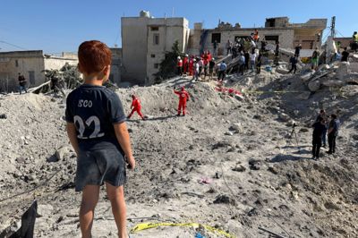 Et barn kigger på murbrokkerne ved en bygning, der lørdag blev beskadiget under et israelsk angreb i Qennarit i det sydlige Libanon.